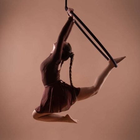 Performerin in einem Kleid in einem Aerial-Hoop