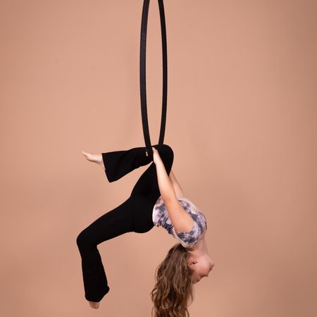 Junges Mädchen kopfüber in einem Aerial-Hoop
