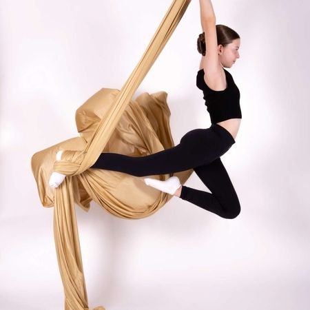 Junge Schülerin macht am Aerial Tuch eine ausdrucksstarke Pose