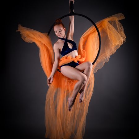 Jolien sitzt in einem Aerial-Hoop mit fliegenden Tüchern