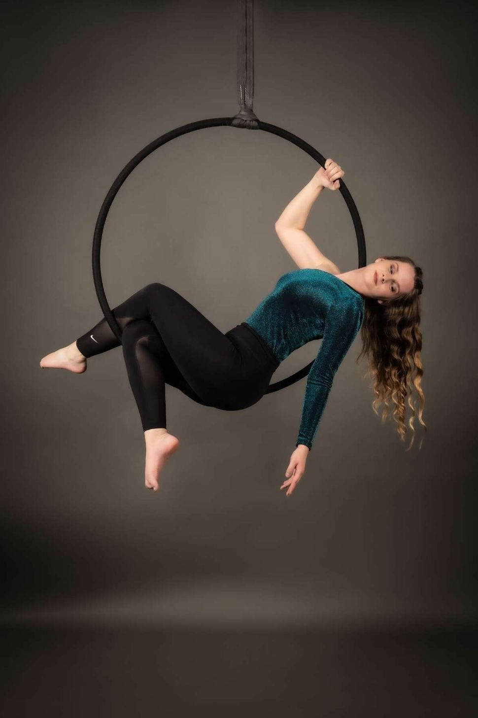Performerin in einem Aerial-Hoop und in festlicher Kleidung